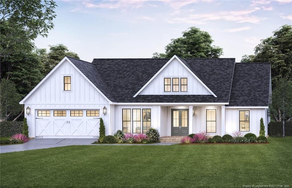 view of front of property with a garage, driveway, a front lawn, and board and batten siding