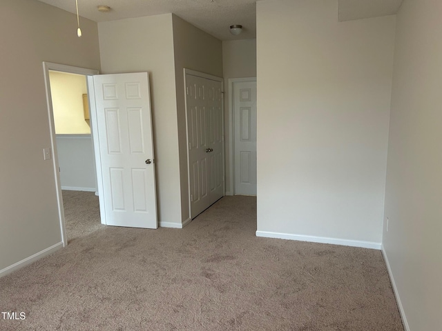 unfurnished bedroom with carpet floors, a closet, and baseboards