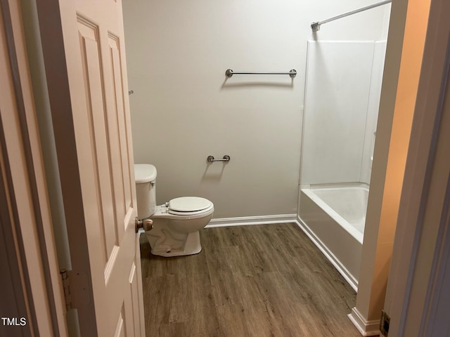 full bathroom with baseboards, tub / shower combination, toilet, and wood finished floors