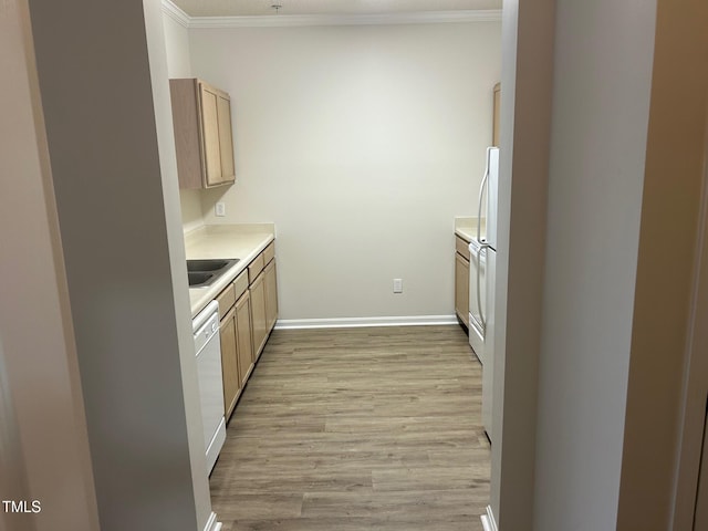 kitchen featuring a sink, light countertops, ornamental molding, dishwasher, and light wood finished floors