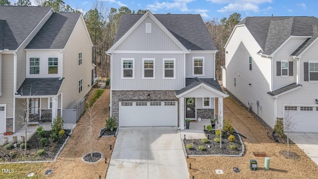 view of front of property with board and batten siding, stone siding, a garage, and concrete driveway