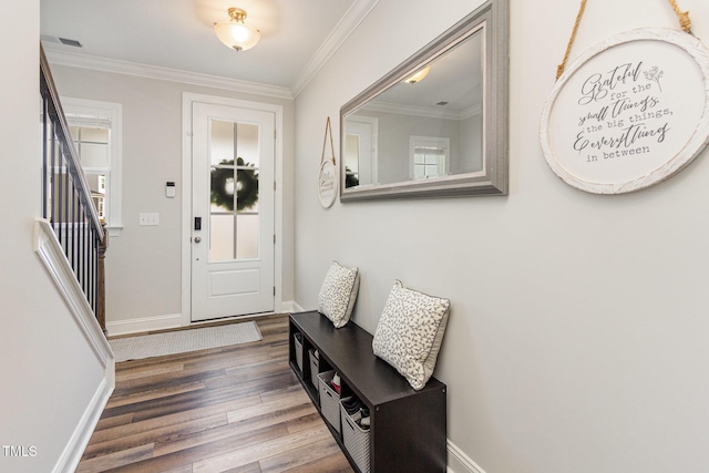 foyer entrance featuring stairs, ornamental molding, wood finished floors, and visible vents