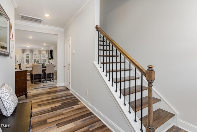 stairway featuring crown molding, recessed lighting, visible vents, wood finished floors, and baseboards