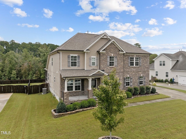 view of front facade with brick siding, covered porch, fence, cooling unit, and a front lawn