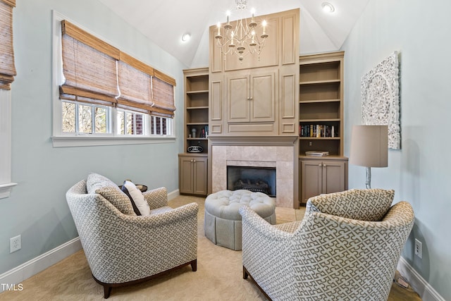 living area featuring lofted ceiling, a fireplace, baseboards, and a notable chandelier