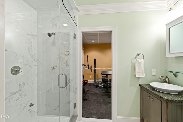 bathroom featuring baseboards, a marble finish shower, vanity, and crown molding