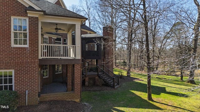 view of jungle gym with a sunroom, ceiling fan, stairway, and a lawn