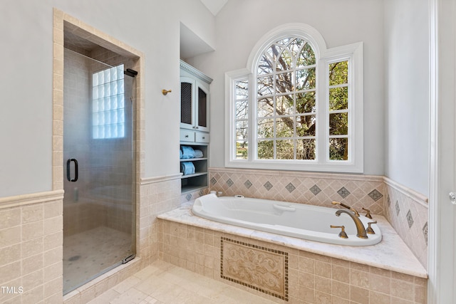 bathroom with a garden tub, a shower stall, and a wealth of natural light