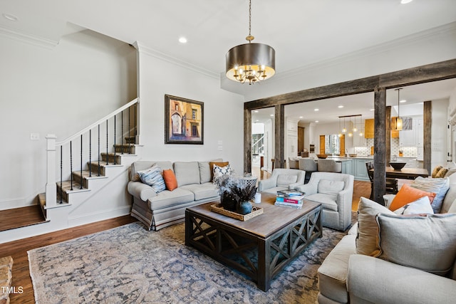 living room with recessed lighting, wood finished floors, stairway, an inviting chandelier, and crown molding