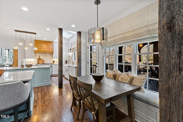 dining room with dark wood-style floors, a skylight, and recessed lighting