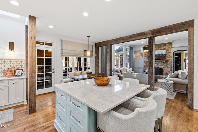 kitchen with recessed lighting, light wood-style flooring, open floor plan, and decorative light fixtures