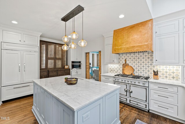 kitchen featuring high quality appliances, custom exhaust hood, dark wood finished floors, and decorative backsplash