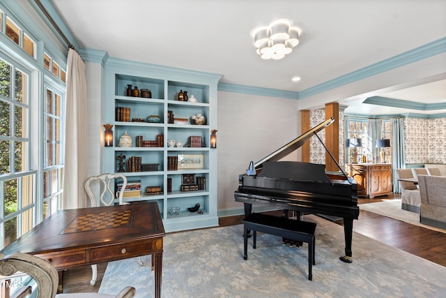 sitting room featuring plenty of natural light, wood finished floors, and crown molding