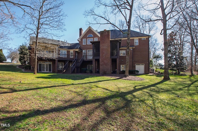 rear view of house with a deck, brick siding, a yard, stairway, and a chimney