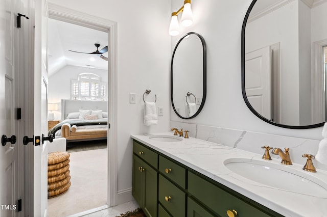 ensuite bathroom with double vanity, connected bathroom, a sink, and lofted ceiling