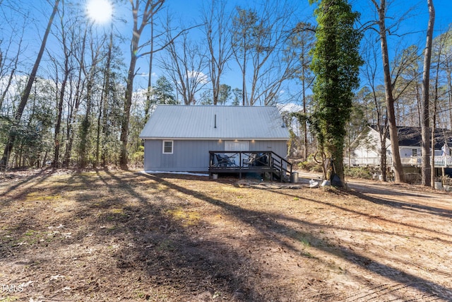 back of house with metal roof and a wooden deck