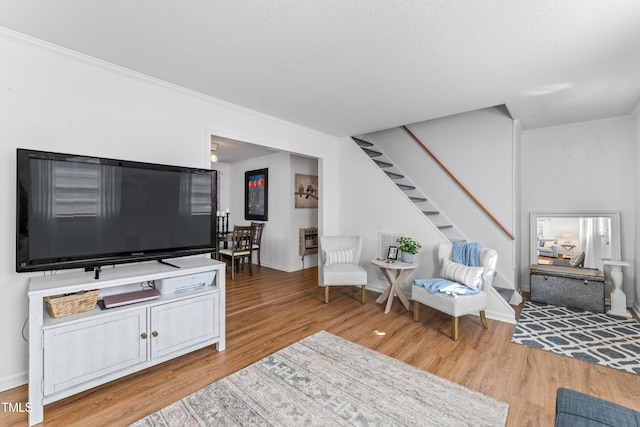 living room with stairs, ornamental molding, heating unit, and wood finished floors