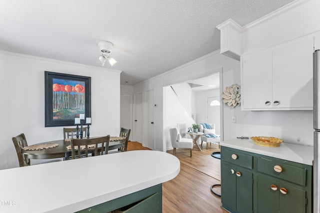 kitchen featuring light wood-type flooring, white cabinets, light countertops, and green cabinets