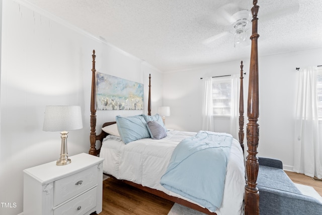 bedroom with a textured ceiling, a ceiling fan, and wood finished floors