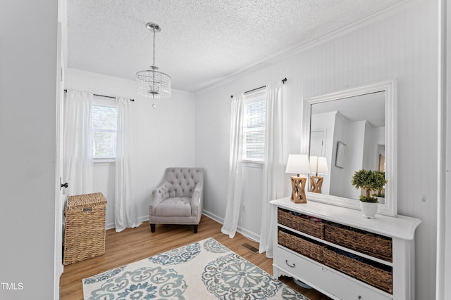 living area with light wood-style flooring, a textured ceiling, and a wealth of natural light