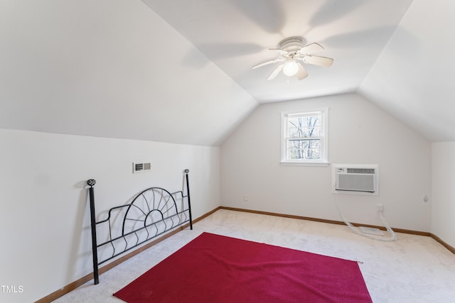 additional living space featuring baseboards, visible vents, vaulted ceiling, an AC wall unit, and carpet floors