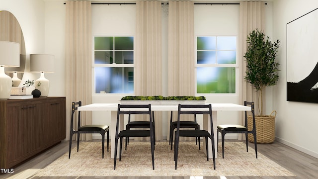 dining area featuring breakfast area, light wood-style floors, and baseboards