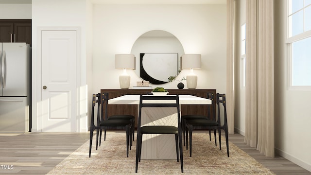 dining space featuring baseboards and light wood-style floors