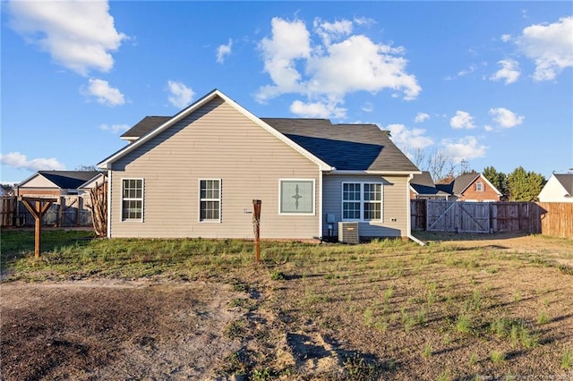 rear view of property with a yard and fence