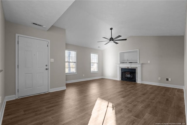 unfurnished living room featuring dark wood-style floors, visible vents, a ceiling fan, vaulted ceiling, and a tile fireplace