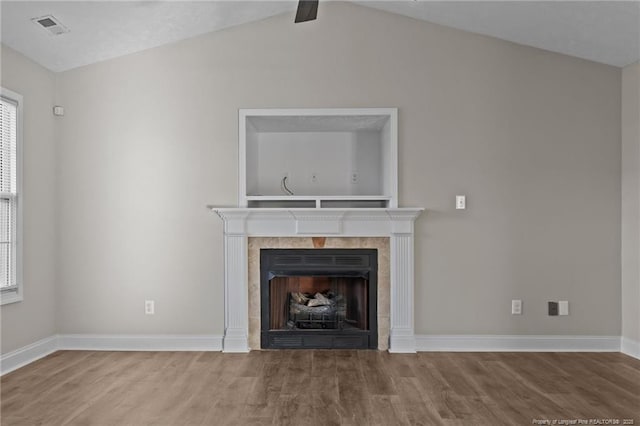 unfurnished living room with baseboards, visible vents, a tiled fireplace, and wood finished floors