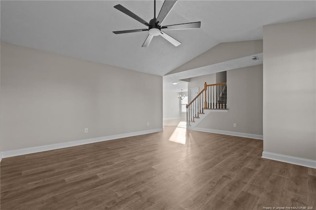 spare room featuring stairs, dark wood-style floors, a ceiling fan, and baseboards