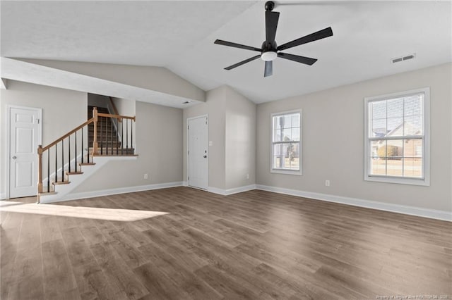 unfurnished living room featuring wood finished floors, visible vents, baseboards, and stairs