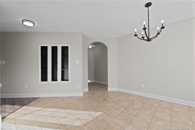 unfurnished room with an inviting chandelier, baseboards, arched walkways, and light tile patterned flooring