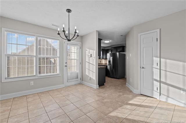 unfurnished dining area with baseboards, light tile patterned flooring, visible vents, and an inviting chandelier