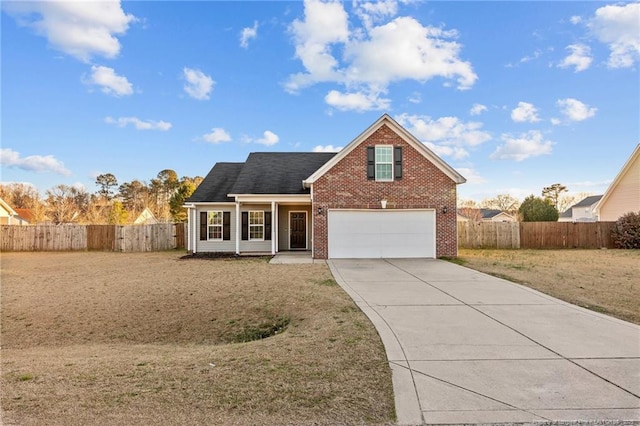 traditional-style home with driveway, a front yard, fence, and brick siding