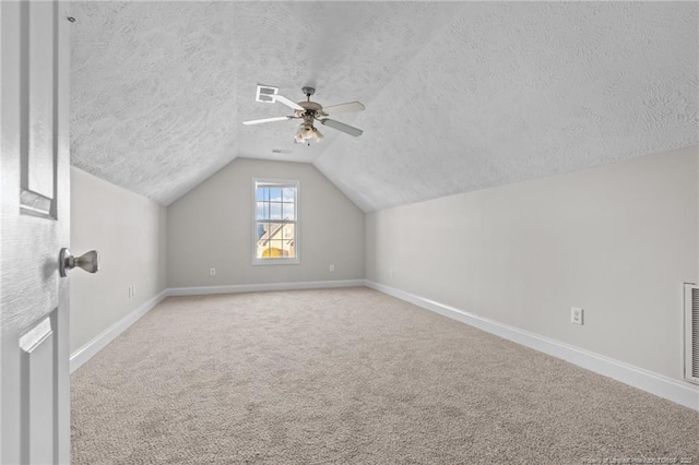 additional living space featuring carpet floors, lofted ceiling, visible vents, and baseboards