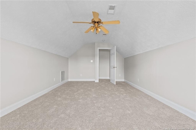 bonus room featuring visible vents, vaulted ceiling, a textured ceiling, and baseboards