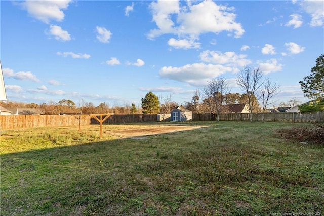 view of yard featuring a shed, an outdoor structure, and a fenced backyard