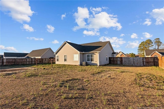 back of property featuring a fenced backyard and a yard