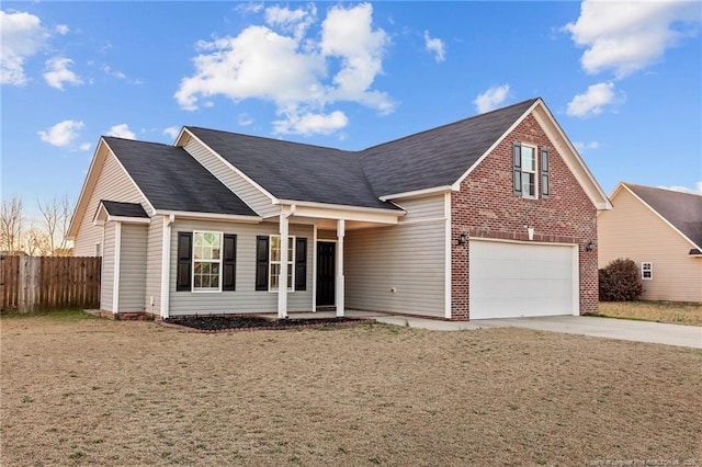 view of front of house featuring concrete driveway, brick siding, a front yard, and fence