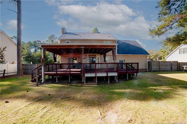 rear view of property featuring a fenced backyard, a lawn, and a wooden deck