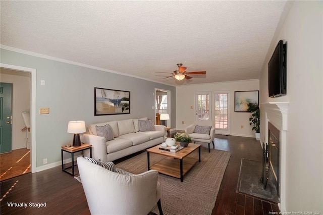 living room with a ceiling fan, dark wood-type flooring, baseboards, and a textured ceiling