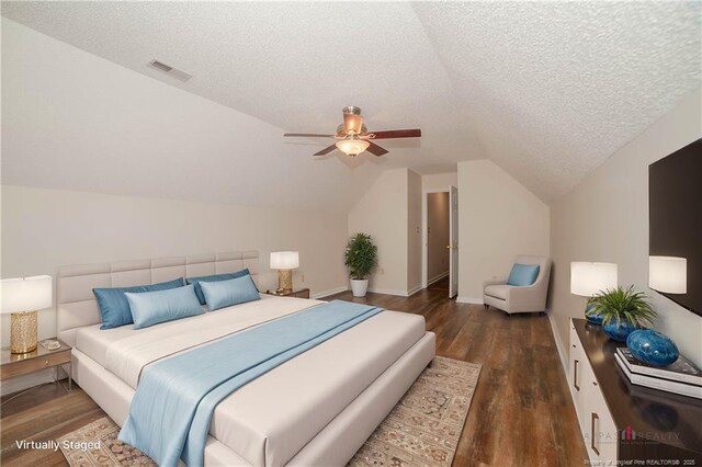 bedroom featuring a textured ceiling, visible vents, ceiling fan, wood finished floors, and lofted ceiling