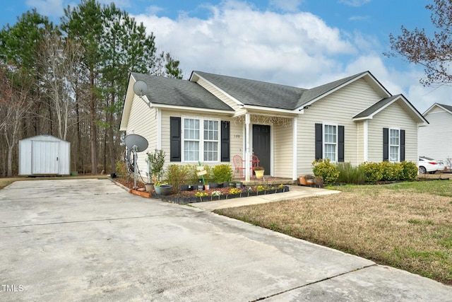 ranch-style home featuring a front yard, roof with shingles, an outbuilding, and a storage shed