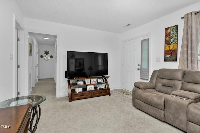 living room with baseboards, a textured ceiling, visible vents, and carpet flooring