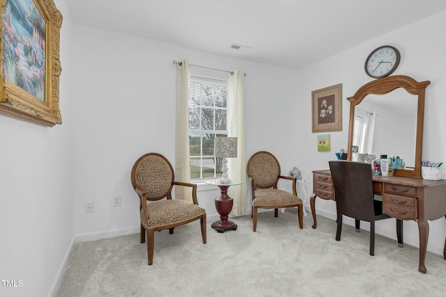 living area with baseboards and light colored carpet