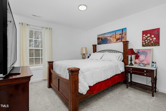 bedroom featuring baseboards, visible vents, and light colored carpet