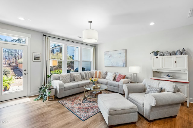 living area featuring baseboards, light wood-style flooring, and recessed lighting