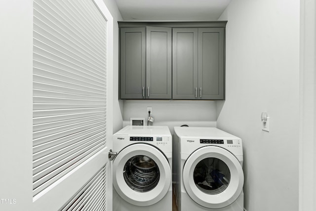 clothes washing area with washing machine and dryer and cabinet space