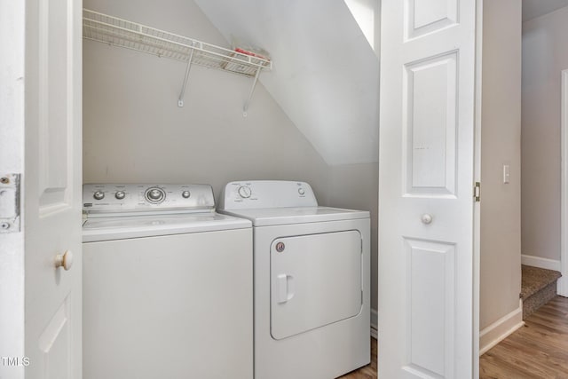 laundry area with washing machine and dryer, laundry area, baseboards, and light wood finished floors